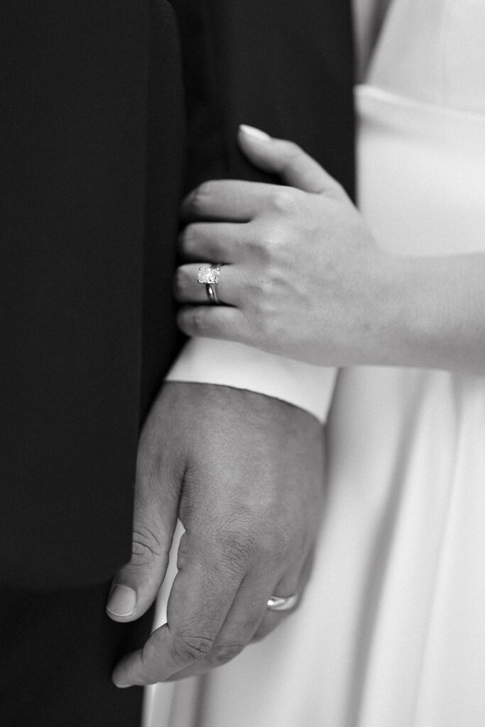 Black and white image of intimate close-up of couple holding hands at cooper glass chapel. 