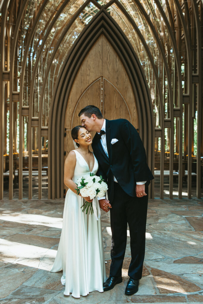 Bride and groom kissing outside the doors of mildred b. cooper memorial chapel.