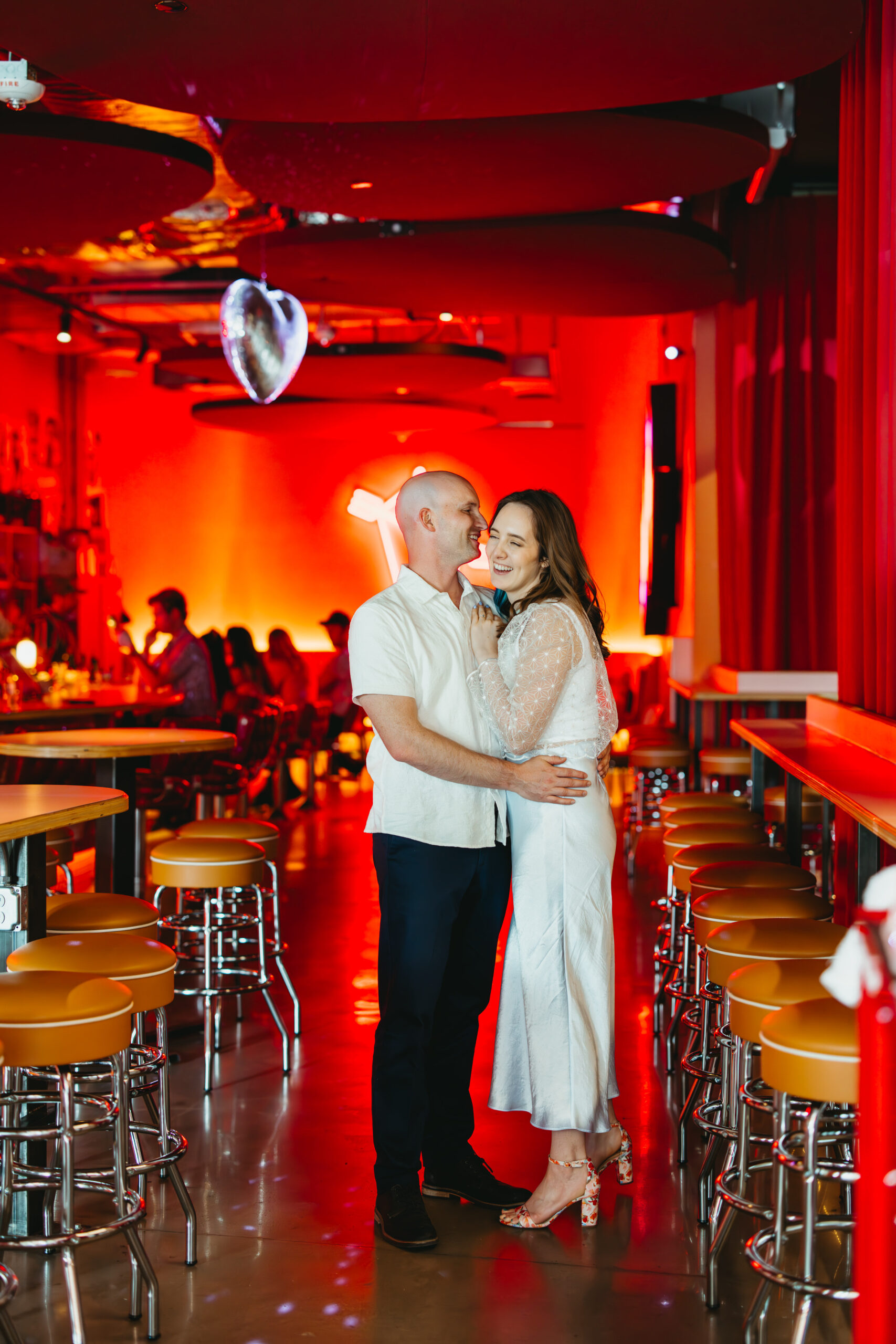 Playful kiss captured with dramatic flash in a bold Bentonville engagement shoot for their save the date.