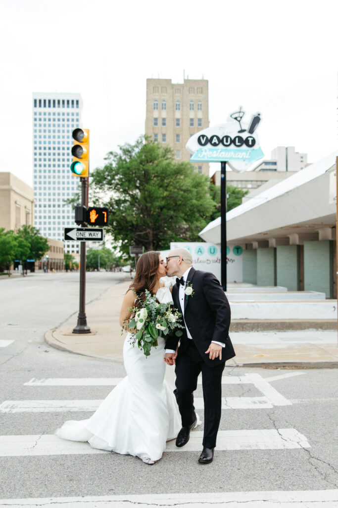 Bride & groom walking down sidewalk near The Vault in downtown Tulsa, Oklahoma